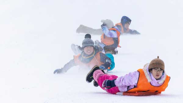 米袋を使って雪滑りを競う「米そり」