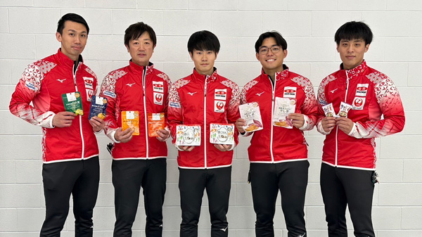 「ニッポンの食」を手にするカーリング男子日本代表（写真提供：JCA）