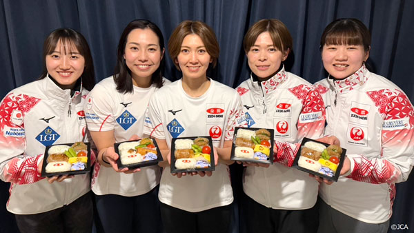 「おにぎり弁当」を手に笑顔のカーリング女子日本代表選手（提供：JCA）