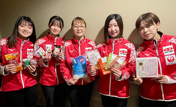 「ニッポンの食」を手にするカーリング女子日本代表（写真提供：JCA）