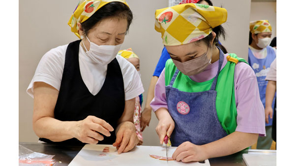 指導を受けながら食材を切る子ども