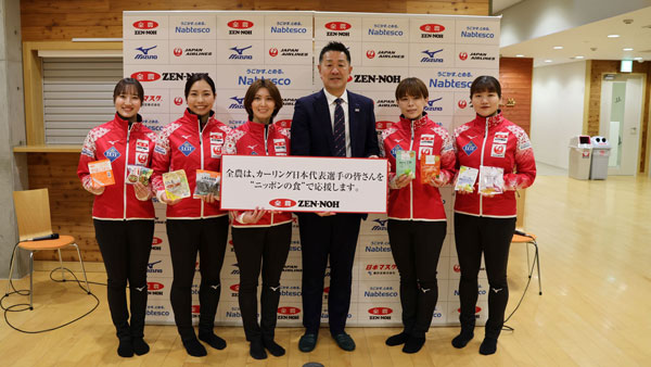 「ニッポンの食」を手にするカーリング女子日本代表