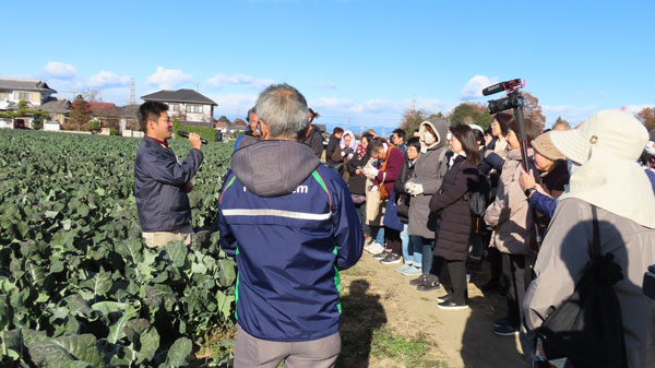 圃場内で生産者の説明を聞く参加者