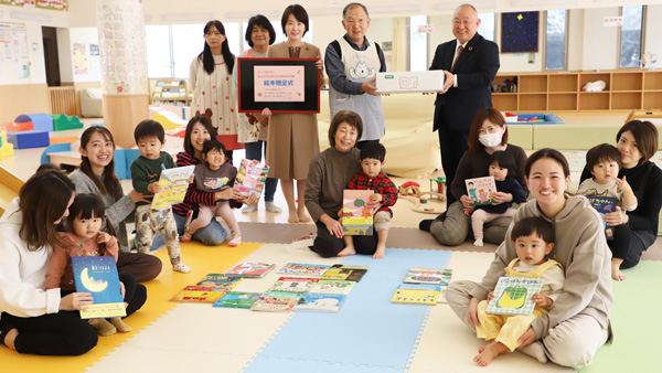 「館山市元気な広場」の施設長に絵本を寄贈する、コープみらい熊﨑伸理事長（後列右）