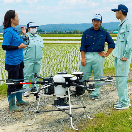 ナイルワークスのスタッフ（左）から自動飛行ドローンについて説明を受ける農業科作物専攻班の3年生